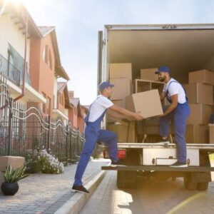 image shows two men loading boxes into a moving truck